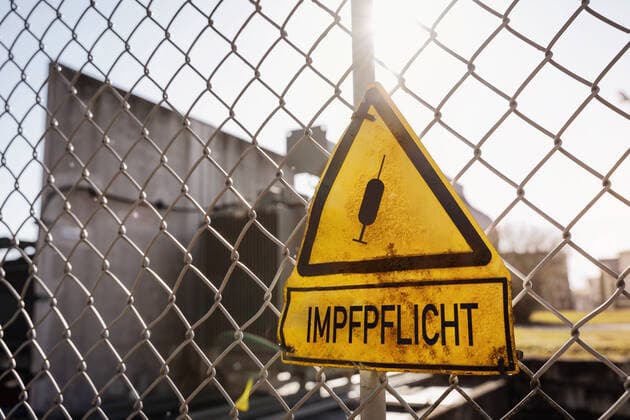 Impfpflicht - Warnschild mit der Aufschrift Impfpflicht, Symbolbild für eine Allgemeine Covid-19 Coronavirus Pflicht zur Impfung xFOTOMONTAGEx