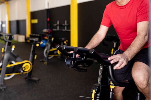 Athlete exercising on bike in gym model released property released, JPTF00944