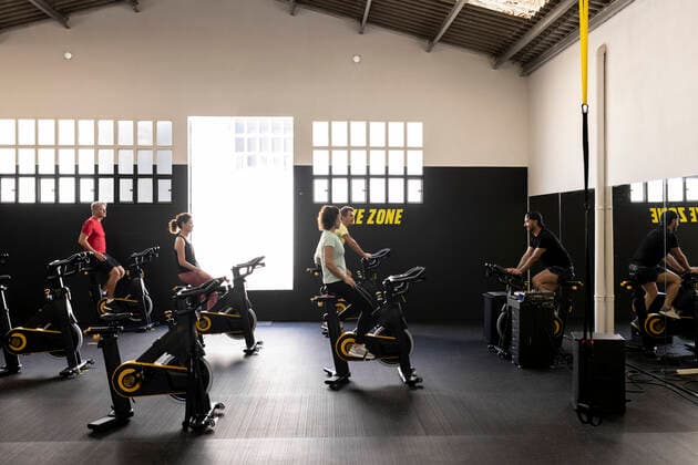 Coach instructing athletes cycling in gym model released property released, JPTF00947