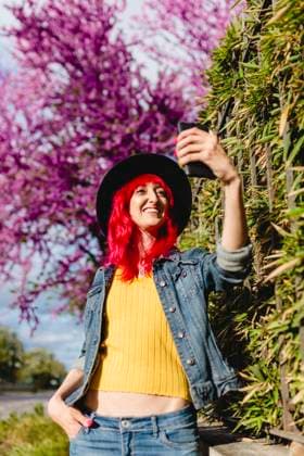 IMAGO Creative, Jahreszeit Frühling, Licht und Sonne Woman with hand in pocket taking selfie through smart phone on sunny day model released, MRRF01746