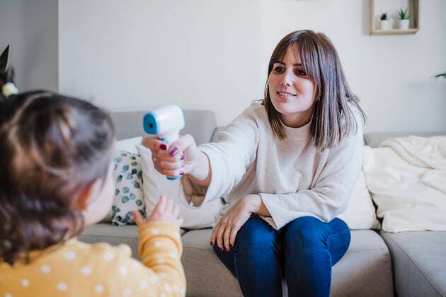 Mother measuring temperature of baby girl at home model released property released, EBBF05092