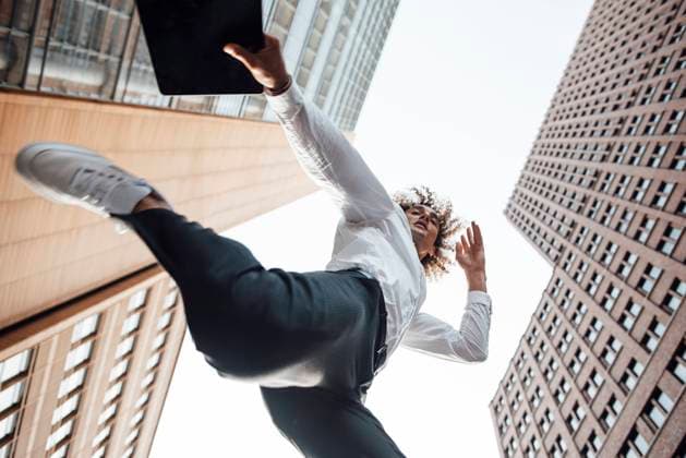 Excited businessman holding digital tablet jumping amidst office buildings model released, GUSF06710