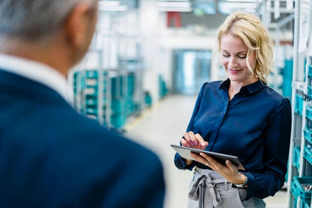 IMAGO Creative: Business, Inflation und Lieferketten Smiling businesswoman using tablet PC with coworker in factory model released property released, DIGF17311