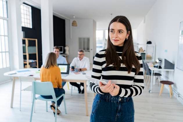 Contemplative businesswoman with tablet PC standing in modern office model released property released, GIOF14530