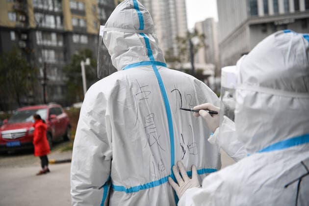 (211227) -- XI AN, Dec. 27, 2021 -- A community worker writes encouraging words on the protective suit of government worker Lu Chenyang in Yanta District of Xi an, northwest China s Shaanxi Province, Dec. 27, 2021. Tens of thousands of government workers have joined the frontline across the city to stamp out coronavirus in Xi an, capital of northwest China s Shaanxi Province. ) CHINA-SHAANXI-XI AN-COVID-19-PREVENTION AND CONTROL-GOVERNMENT WORKER (CN) ZhangxBowen 