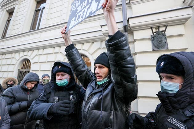 MOSCOW, RUSSIA â€“ DECEMBER 28, 2021: A Memorial Society supporter and law enforcement officers are seen outside the Russian Supreme Court during a hearing of arguments of the Russian Prosecutor General s Office and international public organization Memorial Society (a non-profit organization declared a foreign agent in Russia). Earlier, the Russian Prosecutor General s Office filed a motion to disband the international public organization Memorial Society (a non-profit organization declared a foreign agent in Russia) and its subdivisions for violating the Foreign Agent law. Founded in 1989, Memorial is an international historical society researching the political repressions and monitoring human rights in the present-day Russia and other p  TS11D8F5