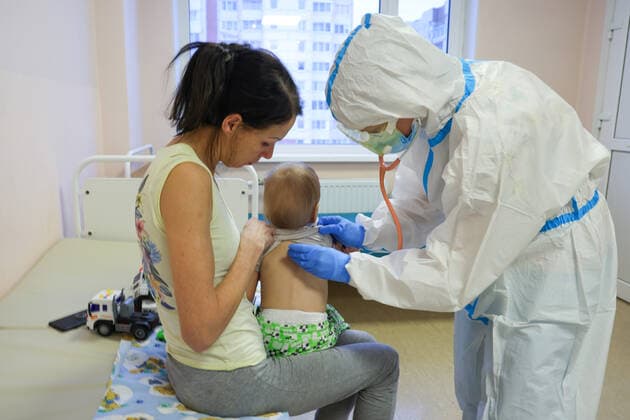 ST PETERSBURG, RUSSIA â€“ DECEMBER 29, 2021: A medical worker attends a patient with a child in the red zone of a COVID-19 ward at the Filatov children s city clinical hospital No 5 treating young COVID-19 patients. Peter Kovalev TASS  TS11DAE4