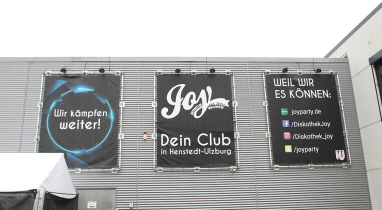 Die Diskothek Joy am Kirchweg 119 in Henstedt-Ulzburg. Wie der Infektionsschutz des Kreises Segeberg am 29. Dezember mitgeteilt hat, müssen sich alle Personen, die an Heiligabend und oder am ersten Weihnachtsfeiertag den Club besucht haben, sich unmittelbar in Quarantäne zu begeben. Laut dem Gesundheitsamt wurde bei mindestens einem der Besucher der Partys eine Corona-Infektion mit Verdacht auf die Omikron-Variante bestätigt. Deswegen müssen sich auch genesene und geimpfte Kontaktpersonen für 14 Tage isolieren. Nach Angaben von Joy-Geschäftsführer Joey Claussen handelt es sich insgesamt rund 820 Personen, die an beiden Tagen seine Disco besucht haben. Es wurde an beiden Tagen nach der 2G-Plus-Regelung verfahren. Laut dem Kreis