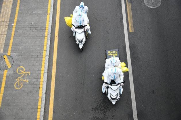 (211231) -- XI AN, Dec. 31, 2021 -- Delivery riders escort medical staff to a nucleic acid sampling site in Xi an, northwest China s Shaanxi Province, Dec. 30, 2021. After the outbreak of COVID-19 in Xi an, many delivery riders volunteer to deliver daily necessities and register information for nucleic acid test. ) CHINA-SHAANXI-XI AN-COVID-19-DELIVERY RIDERS-VOLUNTEERS (CN) LixYibo 