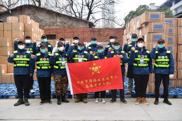 (211231) -- XI AN, Dec. 31, 2021 -- A volunteer team consisting of veterans pose for a group photo in Xi an, northwest China s Shaanxi Province, Dec. 31, 2021. More than 100,000 frontline workers and volunteers are participating in the epidemic prevention and control efforts in Xi an. ) CHINA-SHAANXI-XI AN-COVID-19-VOLUNTEERS (CN) ZhangxBowen 