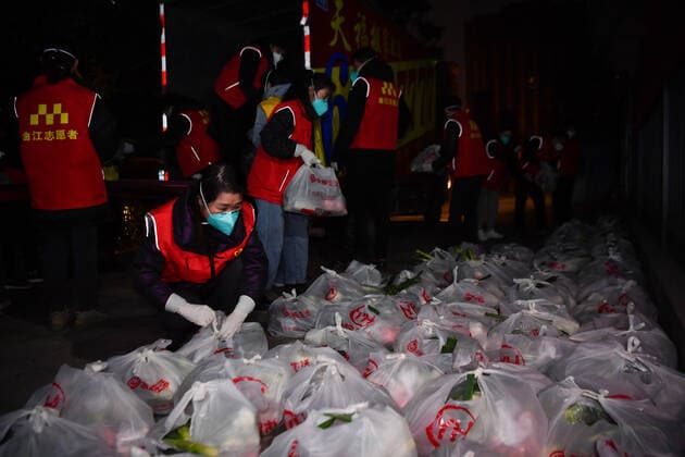 (220101) -- XI AN, Jan. 1, 2022 -- Volunteers sort supplies to be delivered to households for free at a residential area in Xi an, northwest China s Shaanxi Province, Dec. 31, 2021. Staff members and volunteers stuck to their posts on the New Year s eve to ensure supplies of daily necessities for the residents under lockdown and help contain the COVID-19 resurgence in Xi an. ) CHINA-SHAANXI-XI AN-COVID-19-NEW YEAR S EVE (CN) ZhangxBowen 