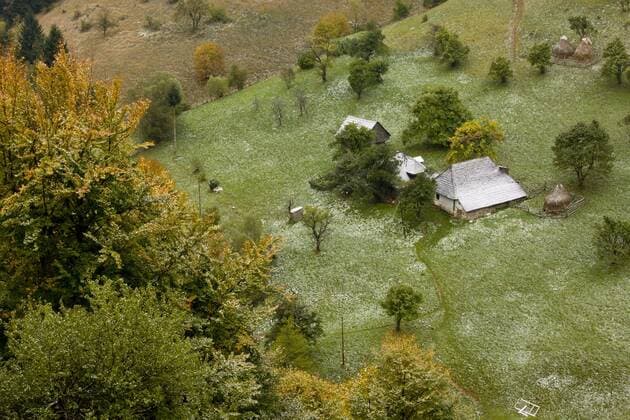 Blick auf traditionelles Ackerland, mit alten Häusern, Scheunen, Obstbäumen und Weiden unter leichter Schneedecke im Herbst, Dorf Magura, Piatra Craiulu-Gebirge, Südkarpaten, Rumänien, Oktober, Europa *** View of traditional farmland, with old houses, barns, fruit trees and pastures under light snow cover in autumn, Magura village, Piatra Craiulu Mountains, Southern Carpathians, Romania, October, Europe Copyright: imageBROKER BobxGibbons iblhoj05619677.jpg