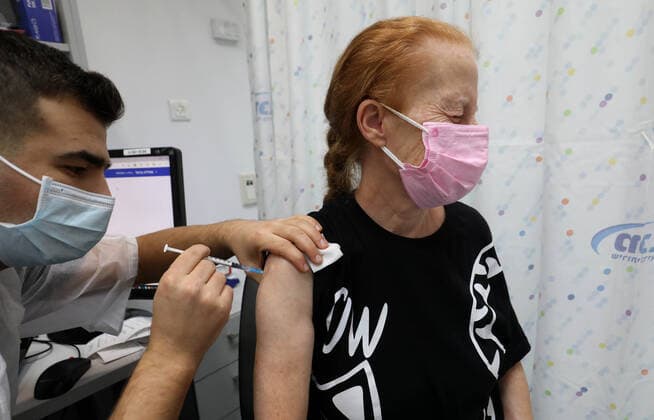(220103) -- RISHON LEZION, Jan. 3, 2022 -- A woman receives her fourth dose of COVID-19 vaccine at a clinic in Rishon Lezion, Israel, on Jan. 3, 2022. Israel on Monday reported 6,570 new COVID-19 cases, bringing the total number of infections in the country to 1,403,821, or nearly 15 percent of the total population, the state s health ministry said. (Photo by Xinhua) ISRAEL-RISHON LEZION-COVID-19-CASES GilxCohenxMagen