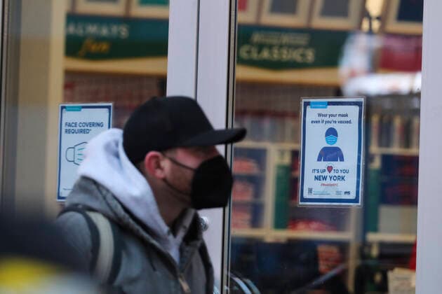 (220105) -- NEW YORK, Jan. 5, 2022 -- A pedestrian walks past a store with a notice of wearing mask on its door in New York, the United States, Jan. 4, 2022. Nearly all new U.S. COVID-19 cases last week were linked to the Omicron variant, the Centers for Disease Control and Prevention (CDC) reported on Tuesday, as the highly transmissible new strain has quickly overtaken the Delta variant and sparked new surges nationwide. ) U.S.-NEW YORK-COVID-19-OMICRON WangxYing 