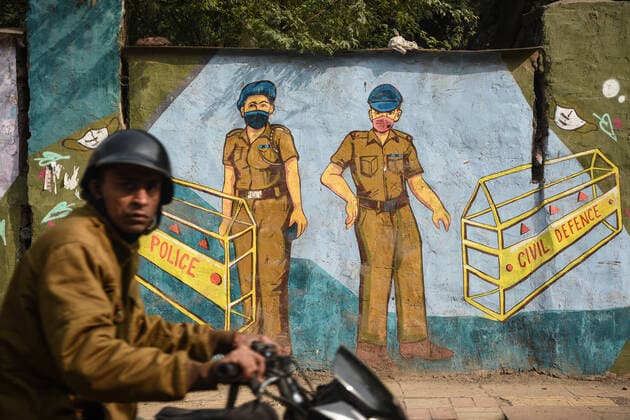 Coronavirus, Eindrücke aus Indien NEW DELHI, INDIA - JANUARY 4: A man rides past a mural art of Delhi Police made on the walls amid the increasing cases of Covid-19 Omicron variant at Rajendra Nagar, on January 4, 2022 in New Delhi, India. (Photo by Sanchit Khanna Hindustan Times ) Daily Life Amid Coronavirus Pandemic In India