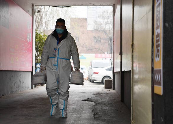 (220105) -- XI AN, Jan. 5, 2022 -- A volunteer leaves Deshan shared kitchen to deliver foods in Yanta District of Xi an, northwest China s Shaanxi Province, Jan. 4, 2022. Located in Yanta District of Xi an, Deshan shared kitchen was run as an anti-cancer kitchen , providing convenience for cancer patients and their families to cook meals. Xu Kai, founder of the shared kitchen, transformed this anti-cancer kitchen into a fight-against-epidemic kitchen after the city has been hit by the recent COVID-19 resurgence. Up to now, more than 30 volunteers have joined the food delivery activities of the kitchen to help not only cancer patients and their families who are stranded in Xi an, but also some personnel who work for the prevention an 