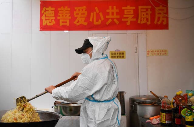 (220105) -- XI AN, Jan. 5, 2022 -- Volunteer Li Guang makes dishes for delivery at Deshan shared kitchen in Yanta District of Xi an, northwest China s Shaanxi Province, Jan. 4, 2022. Located in Yanta District of Xi an, Deshan shared kitchen was run as an anti-cancer kitchen , providing convenience for cancer patients and their families to cook meals. Xu Kai, founder of the shared kitchen, transformed this anti-cancer kitchen into a fight-against-epidemic kitchen after the city has been hit by the recent COVID-19 resurgence. Up to now, more than 30 volunteers have joined the food delivery activities of the kitchen to help not only cancer patients and their families who are stranded in Xi an, but also some personnel who work for the p 
