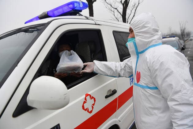 (220105) -- XI AN, Jan. 5, 2022 -- Volunteer Chang Lin delivers foods to an ambulance driver in Yanta District of Xi an, northwest China s Shaanxi Province, Jan. 4, 2022. Located in Yanta District of Xi an, Deshan shared kitchen was run as an anti-cancer kitchen , providing convenience for cancer patients and their families to cook meals. Xu Kai, founder of the shared kitchen, transformed this anti-cancer kitchen into a fight-against-epidemic kitchen after the city has been hit by the recent COVID-19 resurgence. Up to now, more than 30 volunteers have joined the food delivery activities of the kitchen to help not only cancer patients and their families who are stranded in Xi an, but also some personnel who work for the prevention an 