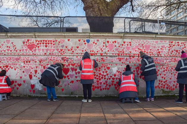 January 7, 2022, London, United Kingdom: Volunteers repaint the hearts on the National Covid Memorial Wall. ?.Volunteers, many of whom have lost family members to coronavirus, are repainting some of the red hearts which have faded over time. Over 150,000 hearts have been painted to date on the wall outside St Thomas Hospital opposite the Houses of Parliament, one for each life lost to COVID-19. London United Kingdom - ZUMAs197 20220107_zaa_s197_042 Copyright: xVukxValcicx