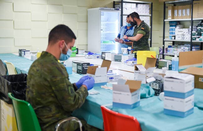 (220108) -- SEVILLE, Jan. 8, 2022 -- Hospital and military personnels work at a vaccination point in Seville University in Seville, Spain, on Jan. 7, 2022. The Spanish Ministry of Health registered 242,440 new cases of the virus from Wednesday to Friday, taking the total number of infections to 7,164,906 in Spain since the start of the pandemic. The Defense Ministry military continue to supply personnel to help with contact tracing and vaccination. (Photo by Xinhua) SPAIN-COVID-19-CASES GustavoxValiente 