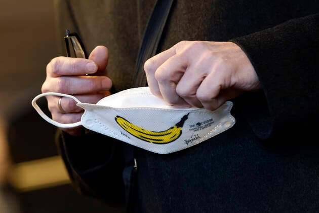 Ein Mundschutz mit der typischen Spraybanane von Thomas Baumgärtel bei der Vorstellung der Buttons mit der Impfbanane im Impfzentrum der Stadt Köln in der Lanxess-Arena. Hier werden auch Kinder (5-11 Jahre) geimpft. Vollständig geimpfte Kinder erhalten als Geschenk einen Button sowie eine Tapferkeitsurkunde. Die Buttons mit der Impfbanane sollen zudem an zahlreichen weiteren Impfstellen verteilt werden. Köln, 07.01.2022