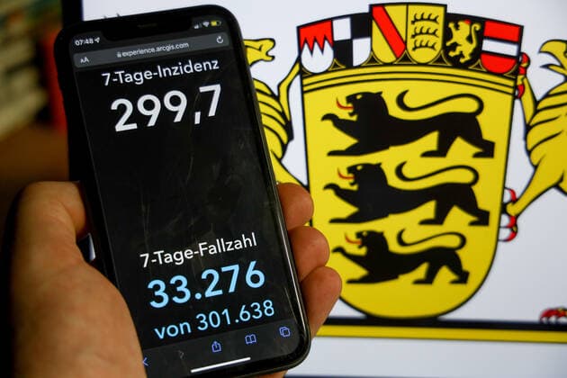 Coronavirus in Deutschland - Covid-19-Dashboard des Robert Koch-Institut DEU, Deutschland, Baden-Württemberg 09.01.2022: Die 7-Tage-Inzidenz für das Bundesland (Fälle letzte 7 Tage 100.000 EW) wird auf einem iPhone angezeigt, im Hintergrund das Landeswappen