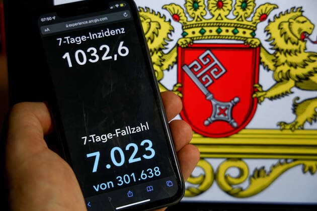 News Bilder des Tages Coronavirus in Deutschland - Covid-19-Dashboard des Robert Koch-Institut DEU, Deutschland, Bremen 09.01.2022: Die 7-Tage-Inzidenz für das Bundesland (Fälle letzte 7 Tage 100.000 EW) wird auf einem iPhone angezeigt, im Hintergrund das Landeswappen