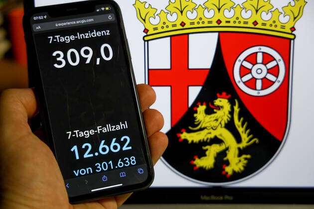 Coronavirus in Deutschland - Covid-19-Dashboard des Robert Koch-Institut DEU, Deutschland, Rheinland-Pfalz 09.01.2022: Die 7-Tage-Inzidenz für das Bundesland (Fälle letzte 7 Tage 100.000 EW) wird auf einem iPhone angezeigt, im Hintergrund das Landeswappen