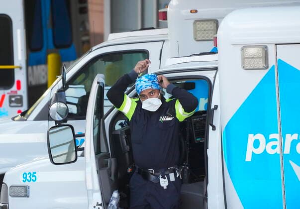 January 10, 2022, TORONTO, ON, CANADA: A paramedic adjusts his protective mask as he transfers a patient out of an ambulance to the emergency department at Michael Garron Hospital during the COVID-19 pandemic in Toronto on Monday, January 10, 2022. Ambulances have been in short supply in some regions through out the province of Ontario. TORONTO CANADA  - ZUMAc35_ 20220110_zaf_c35_022 Copyright: xNathanxDenettex