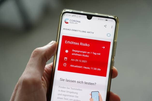 Feature: Die Corona Warn App auf einem Smartphone zeigt rot *** Feature The Corona Warn app on a smartphone shows red MR:Y