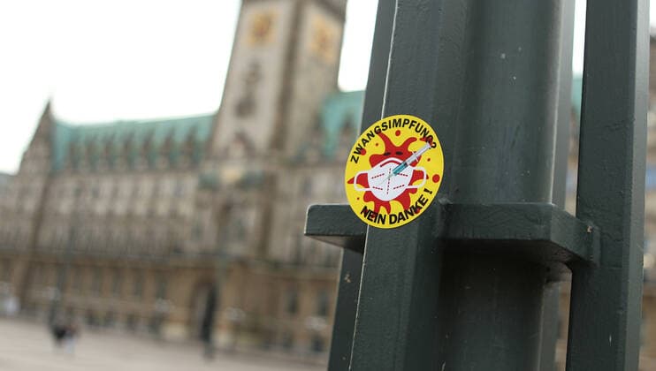 Gegner der Corona-Impfpflicht haben an einen Laternenpfahl auf dem Hamburger Rathausplatz einen Aufkleber befestigt, auf dem der Schriftzug: Zwangsimpfung? Nein Danke! steht. Altstadt Hamburg *** Opponents of Corona compulsory vaccination have attached a sticker to a lamppost on Hamburgs Rathausplatz, which reads compulsory vaccination No Thanks Old Town Hamburg