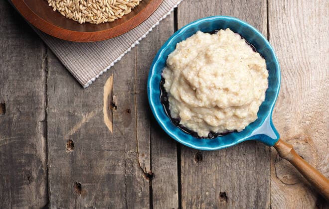IMAGO Nature: Unsere Erde, Klimawandel, Ernährung, Pflanzen der Zukunft, Hafer Tasty organic porridge in a blue ceramic bowl on a rustic wooden kitchen table