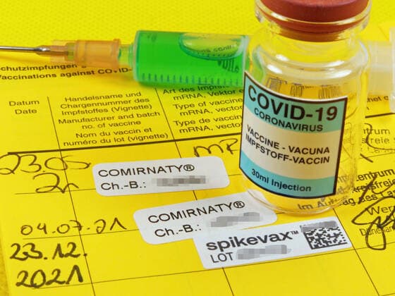 Booster Covid-19 Eintrag in einem Impfpass nach Impfung mit Moderna Impfstoff mit Impfampulle. Booster Impfung-Covid-19