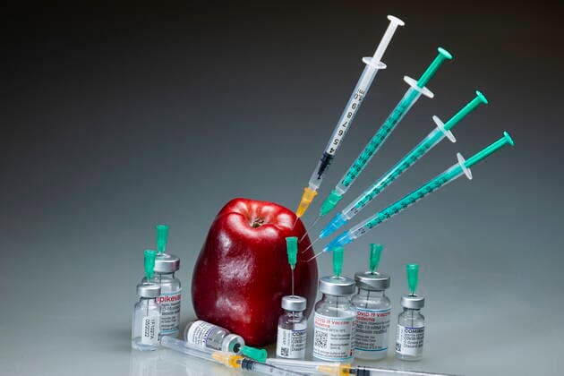 Covidmotiv Symbolbild Impfung eine Coronaspritze steckt in einem roten Apfel. Bannewitz Sachsen GERMANY
