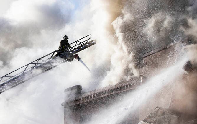 (220115) -- TORONTO, Jan. 15, 2022 -- A firefighter works to extinguish a fire burning at an apartment building in Toronto, Canada, on Jan. 15, 2022. Eleven people were rescued, among whom four were taken to hospital following a four-alarm fire at a low-rise apartment building in Toronto on Saturday morning, according to local media. (Photo by Xinhua) CANADA-TORONTO-APARTMENT BUILDING-FIRE ZouxZheng 