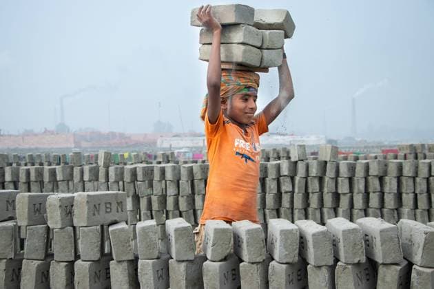 January 18, 2022, Narayanganj, Dhaka, Bangladesh: A child worker is taking piles of bricks on the heads in a brick field in Narayanganj, Bangladesh. Bangladesh, with its 160 million inhabitants, is a country in constant demand for bricks as the primary material for construction of buildings in the era of urbanization. There are approximately 5000 privately operated brick kilns within Bangladesh, including 1000 around the capital, Dhaka. Brick kilns, indirectly responsible for climate change, emit toxic fumes containing large amounts of carbon monoxide, nitrogen oxide and oxides of Sulphur which are extremely harmful to the eyes, lungs and throat and causes environmental degradation. Brick labors work for 12-14 hours a day, six days a week, - ZUMAs231 20220118_zip_s231_031 Copyright: xJoyxSahax