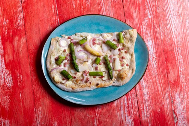 französischer Flammkuchen auf rotem Holz 1035308862