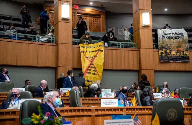 January 18, 2022, USA: A group of protesters display signs, shout chants and disrupt the start of the Governor s state of the state speech broadcast in the House Chambers Tuesday, January 18 2022. The 2022 legislative session started at the Roundhouse at noon. YUCCA, Youth United for Climate Crisis Action claimed responsibility for the action. USA - ZUMAab1_ 20220118_zaf_ab1_006 Copyright: xEddiexMoorex