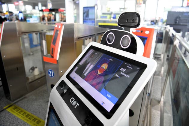 (211219) -- HEFEI, Dec. 19, 2021 -- Da Bai, an intelligent temperature measuring robot, measures a passenger s body temperature at the entrance of Hefei South Railway Station in Hefei, east China s Anhui Province, Jan. 18, 2022. Air environment automatic sterilizer robot Xiao Chuang, intelligent temperature measuring robot Da Bai and ground cleaning and disinfecting robot Xiao De have been in service for COVID-19 prevention and control during the annual Spring Festival travel rush in Hefei. ) CHINA-ANHUI-RAILWAY STATION-ROBOTS (CN) LiuxJunxi 