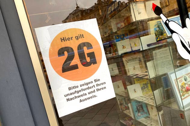 Bayern kippt 2G-Regel im Einzelhandel. Archivfoto: Kontrolle der 2G Regel im Einzelhandel in Bayern. Ein Schild am Eingang eines Geschaeftes weist auf die 2G Regel hin.Einlass nur mit FFP2 Maske und 2g Nachweis,Impfnachweis und Ausweisdokument bereithalten, Eintritt nur fuer geimpfte oder genesene Kunden,Personen, Impfnachweis und Personalausweis bereithalten.