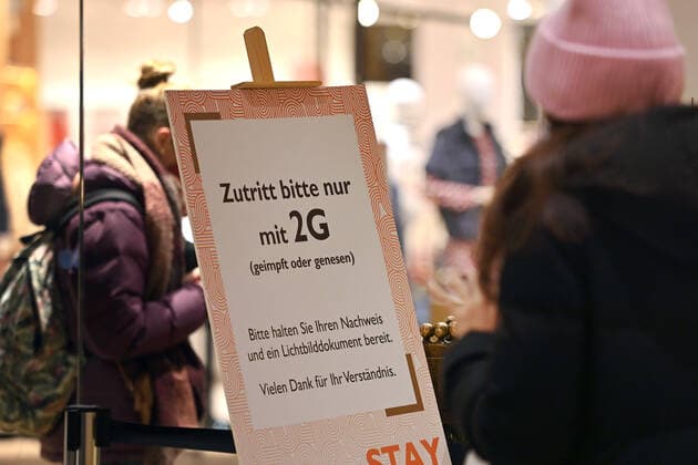 Bayern kippt 2G-Regel im Einzelhandel. Archivfoto:Kontrolle der 2G Regel im Einzelhandel in Bayern. Ein Schild am Eingang eines Geschaeftes weist auf die 2G Regel hin.Einlass nur mit FFP2 Maske und 2g Nachweis,Impfnachweis und Ausweisdokument bereithalten, Eintritt nur fuer geimpfte oder genesene Kunden,Personen, Impfnachweis und Personalausweis bereithalten. Smartphone,Handy.