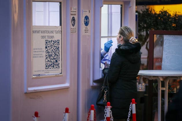 Ein Mitarbeiter eines COVID-19 Testzentrums entnimmt fâˆöÂºr einen Corona Test einen Rachenabstrich bei einer Frau in Duesseldorf, 19.01.2022. Duesseldorf Deutschland Copyright: xLeonxKuegeler photothek.dex