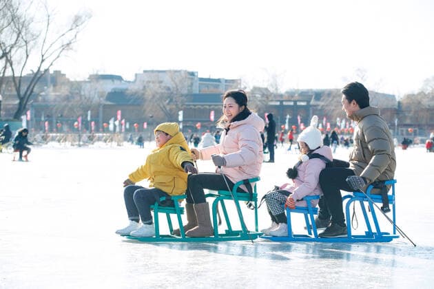 IMAGO Creative: Alternativer Wintersport A family of four sat playing too China, 13 01 2020, model released, Copyright: xViewxStockx, cpmh-189696f30w.jpg, Family,Ice-Skating,Men,Women,Child,Boys,Girls,Togetherness,Snow Vehicle,Ice Rink,Sitting,Playful,Cold,Lake,Frozen,East,china,Happiness,Cheerful,Young Adult,Outdoors,Humor,Arms Outstretched,Oriental Ethnicity,Adult,People,Day,Four People,Warm Clothing,Chinese Ethnicity,Asia,Familial Affection,Young Women,Young Men,Young Couple,Family With Two Children,sisters and brothers,Photography,Color Image,Horizontal,Cityscape,City,Beijing,Shicha Lake,Winter,4-5 Years,6-7 Years,25-29 Years,Winter Olympic Games,Winter Sport,Old Beijing,Tradition Copyright: xViewxStockx