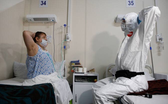 News Bilder des Tages Coronavirus in Russland, Eindrücke aus temporärem Krankenhaus in St. Petersburg ST PETERSBURG, RUSSIA — JANUARY 20, 2022: A patient and a medical staff do physical exercises in the red zone of a field hospital for COVID-19 patients at the LenExpo Exhibition Centre. Since the start of the pandemic, St Petersburg has confirmed more than 897,800 cases of COVID-19. Since 15 January 2022, the number of new confirmed cases has been increasing in St Petersburg by more than 3,000 daily. On 20 January, St Petersburg reported a record high of more than 4,700 new coronavirus cases. With the advance of the omicron strain of coronavirus, the city’s health system has been put on high alert. Valentin Yegorshin TASS TS11FD97