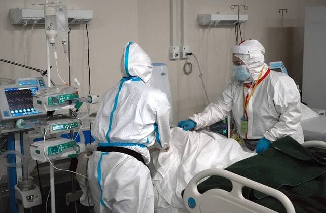 Coronavirus in Russland, Eindr?cke aus tempor?rem Krankenhaus in St. Petersburg Russia Coronavirus Treatment 6745651 20.01.2022 Nurses wearing personal protective equipment (PPE) take care of a patient in an intensive care unit for COVID-19 patients at the hospital deployed at Lenexpo in St. Petersburg, Russia. Alexei Danichev Sputnik St. Petersburg Russia  Copyright: xAlexeixDanichevx