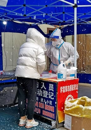 XI AN, CHINA - JANUARY 21: A medical member in protective suit collects a swab from a resident for the COVID-19 nucleic acid test in the snow on January 21, 2022 in Xi an, Shaanxi Province of China.  Copyright: xVCGx CFP111365844751