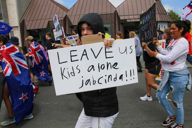 January 22, 2022, Christchurch, Canterbury, New Zealand: A young protester is seen holding a placard that reads Leave us kids alone Jabcinda!!! during the antivax protest in Merivale..Protesters take to the streets in the affluent suburb of Merivale in protest against the mandatory Covid19 vaccination. Christchurch New Zealand - ZUMAs197 20220122_zaa_s197_034 Copyright: xAdamxBradleyx