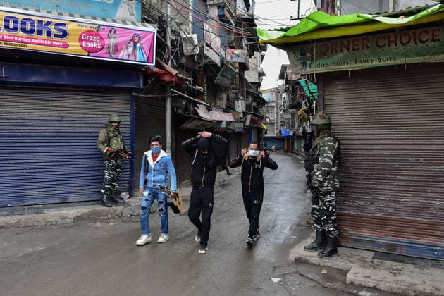January 22, 2022, Srinagar, Jammu & Kas, India: Residents wearing face masks walk past paramilitary troopers standing guard at a closed market during a lockdown imposed by the authorities following the surge in coronavirus cases in Srinagar..Kashmir has been witnessing an exponential surge in Covid-19 cases following which authorities imposed a 64-hour lockdown to curb the surge. Jammu and Kashmir on Friday reported 5,720 coronavirus cases and five deaths. Meanwhile, India reported 337,704 new Covid-19 cases in the last 24 hours. Srinagar India - ZUMAs197 20220122_zaa_s197_046 Copyright: xSaqibxMajeedx
