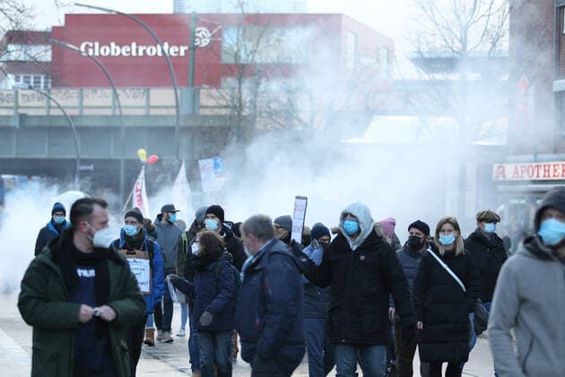 Demonstration von Kritikern der Corona-Maßnahmen in Barmbek. Die Auftaktkundgebung fand auf dem Bert-Kaempfert-Platz statt. Von dort aus setzte sich der Protestzug in Richtung Fuhlsbüttel in Bewegung. Die Demonstranten wurden von einem großen Polizeiaufgebot begleitet. Die Beamten waren mit mehreren Mannschaftswagen und einer Reiterstaffel vor Ort. Auf der Piazzetta-Ralph-Giordano gab es eine kleine Gegendemonstration, an der auch Aktivisten der Antifa teilnahmen. Es kam zu kleinen Handgemengen zwischen ihnen und Polizeikräften. Rauchschwaden über der Fuhlsbütteler Straße, nachdem Gegendemonstranten Pyro gezündet haben. Barmbek Hamburg