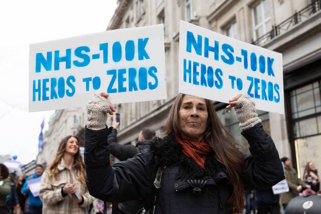 January 22, 2022, London, England, United Kingdom: Protestor seen holding placards that say NHS 100lk heros to zeros during the demonstration..By April 2022, 100k members of the NHS will have to be fully vaccinated or lose their jobs. In light of this draconian requirement, NHS nurses have come together to protest against such coercion, defending their medical freedom and accusing the government for a total mistreatment of the health workers over the pandemic. Other anti-lockdown and anti-vaccine groups have jointly protested against the restrictions imposed by the government, and threaten to take to the streets should the restrictions not be lifted by 27th Jan 2022. London United Kingdom - ZUMAs197 20220122_zaa_s197_140 Copyright: xBelindaxJlaox